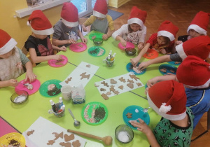 Dzieci wykrawają foremkami ciasto